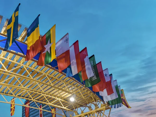 Günbatımı gökyüzünün arka planında Arap ülkelerinin bayrakları