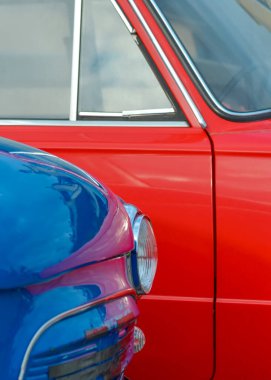 Kırmızı bir arabanın arka planında mavi bir arabanın farları.