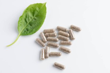 bir şişe beyaz zemin üzerine dışarı dökülmesini ot kapsül