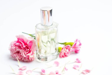 Güzel parfüm şişeleri ve beyaz arka planda pembe karanfiller.