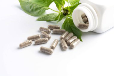 bir şişe beyaz zemin üzerine dışarı dökülmesini ot kapsül