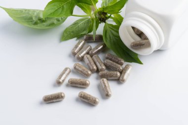 bir şişe beyaz zemin üzerine dışarı dökülmesini ot kapsül