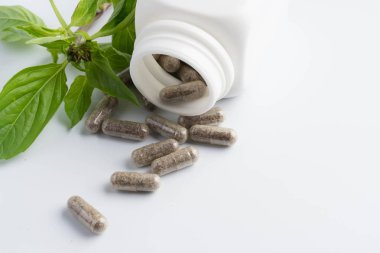 bir şişe beyaz zemin üzerine dışarı dökülmesini ot kapsül