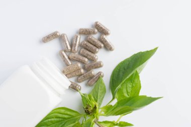 bir şişe beyaz zemin üzerine dışarı dökülmesini ot kapsül