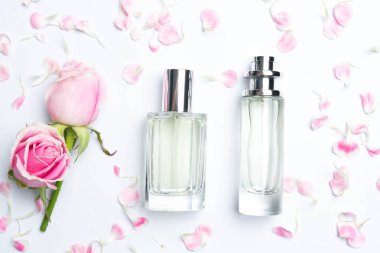 Güzel parfüm şişeleri ve beyaz arka planda gül.