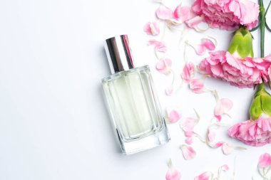 Güzel parfüm şişeleri ve beyaz arka planda pembe karanfiller.