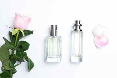 Güzel parfüm şişeleri ve beyaz arka planda gül.