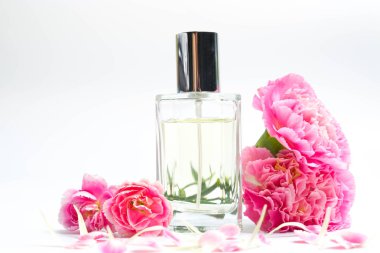 Güzel parfüm şişeleri ve beyaz arka planda pembe karanfiller.