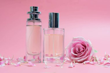 Güzel parfüm şişeleri ve gül pembe bir arka plan üzerinde