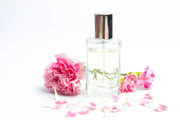 Schöne Parfümflaschen Und Rosa Nelken Auf Weißem Hintergrund — Stockfoto