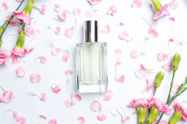 Güzel parfüm şişeleri ve beyaz arka planda pembe karanfiller.