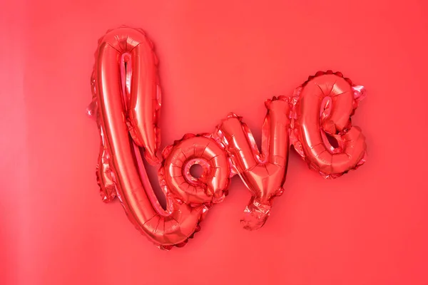 love red foil balloon on pink blackground