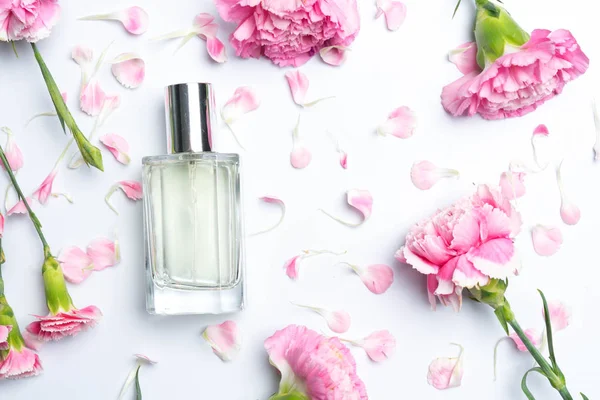 Schöne Parfümflaschen Und Rosa Nelken Auf Weißem Hintergrund — Stockfoto