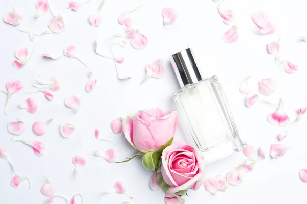 Парфумерні пляшки і троянди на білому тлі — стокове фото