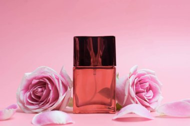 Pembe arka planda parfüm şişeleri