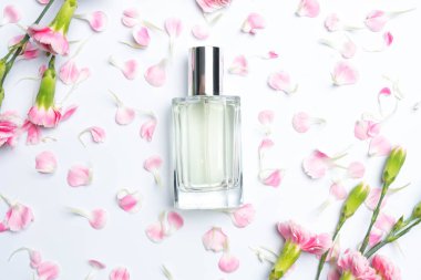 Parfüm şişeleri ve beyaz arka plan üzerinde pembe karanfiller