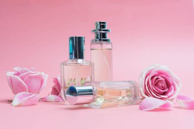 Pembe arka planda parfüm şişeleri