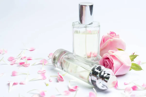 Parfümflaschen und Rose auf weißem Hintergrund — Stockfoto