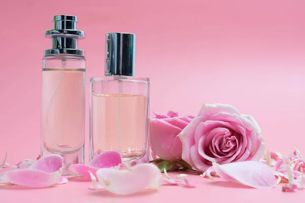 Butelki perfum i Róża na różowym tle — Zdjęcie stockowe