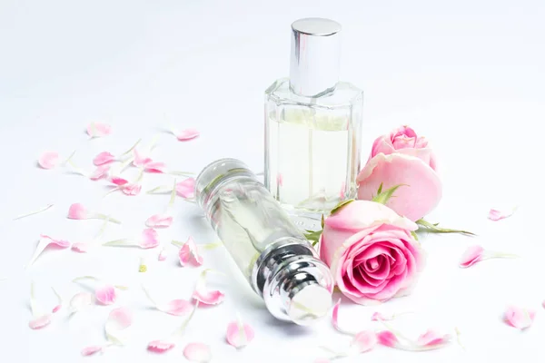 Parfümflaschen und Rose auf weißem Hintergrund — Stockfoto