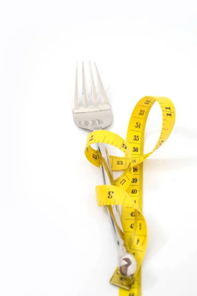 Bir ölçüm bandı diyet veya sağlıklı beslenme ile çatal — Stok fotoğraf