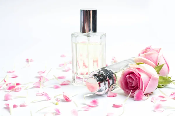 Parfümflaschen und Rose auf weißem Hintergrund — Stockfoto