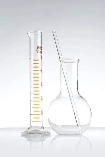 Szklane naczynia laboratoryjne z wodą i puste — Zdjęcie stockowe