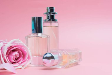 Pembe arka planda parfüm şişeleri