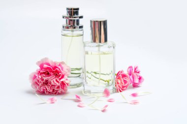 Parfüm şişeleri ve beyaz arka plan üzerinde pembe karanfiller