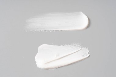 Beyaz arkaplanda beyaz kozmetik yüz kremi dokusu