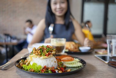 Fesleğenli plat üzerinde kızarmış yumurta ile tepesinde pirinç