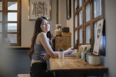 Asyalı kadınlar kafede cep telefonu bilgilere bakın