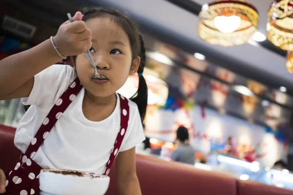 アジアの女の子は喜んでアイスを食べる — ストック写真