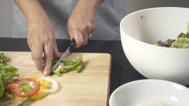 Kadın kesme biber salatası yapmak için taze sebze. 