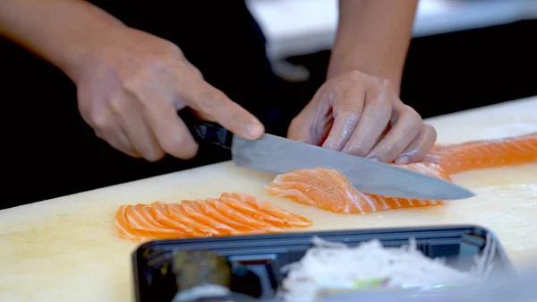 Lo chef sta tagliando il filetto di salmone e organizzandolo in un essere — Foto Stock