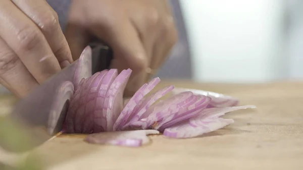 Cebolla en rodajas con cuchillo de cocina sobre tabla de madera, de cerca — Foto de Stock