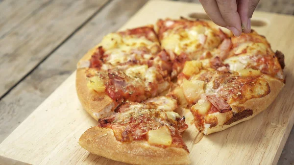 Gros plan femme main saupoudrer origan sur une pizza italienne . — Photo