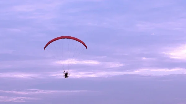 Fallschirm- oder Paramotorflug bei Sonnenuntergang, sportliche Aktivität lizenzfreie Stockbilder