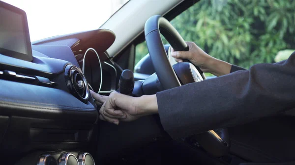 Nahaufnahme der Hand der Frau, sie drückt den Startknopf im modernen Auto. Stockbild