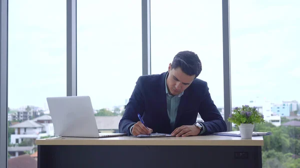 Geschäftsleute arbeiten im computerfähigen Büro und auf Platten Stockbild