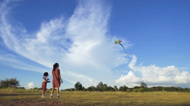 Asya aileleri, anneler, oğulları ve kızları uçurtma oynuyor