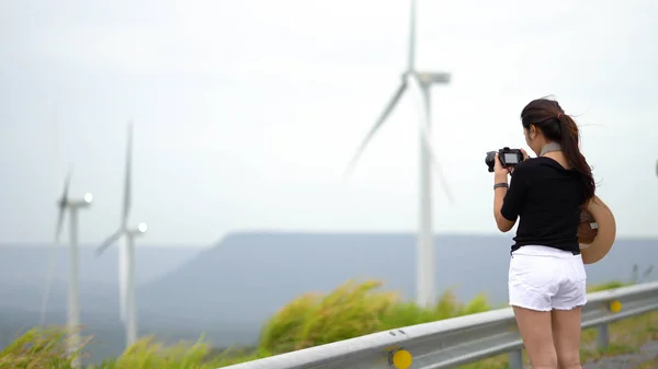 Asian women tourists are taking a picture of a wind turbine at a — Stock Photo, Image