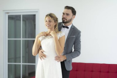 Damat gelin için güzel bir kolye takıyor