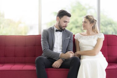 Çiftler oturan ve kırmızı kanepede mutlu konuşma, yeni biz