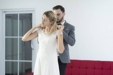 Damat gelin için güzel bir kolye takıyor