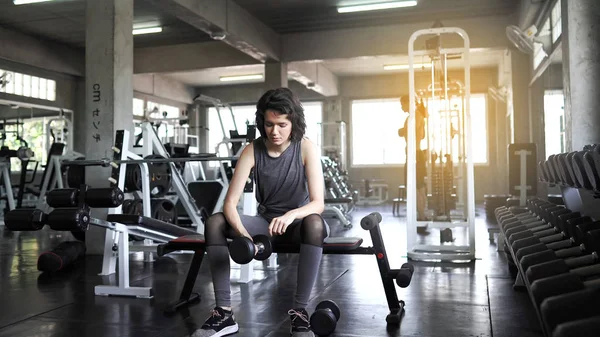 Les jeunes femmes sportives font de l'exercice en soulevant des haltères dans la salle de gym, co — Photo