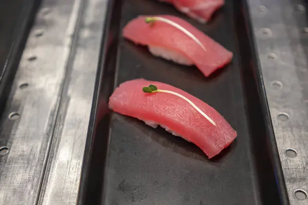 Sushi frente al pescado colocado en una bandeja, restaurante japonés —  Fotos de Stock