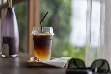 Tahta bir masaya yerleştirilen soğuk siyah kahve içecekleri