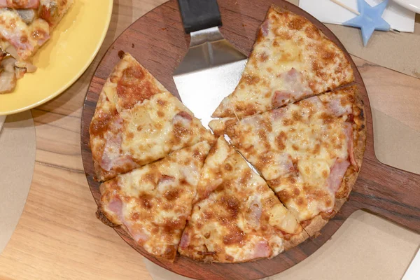 Pizza placed on a wooden tray