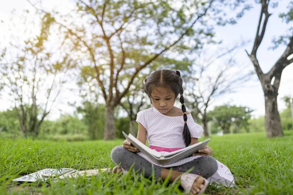 アジアの女の子は公園で本を読んでいます. — ストック写真